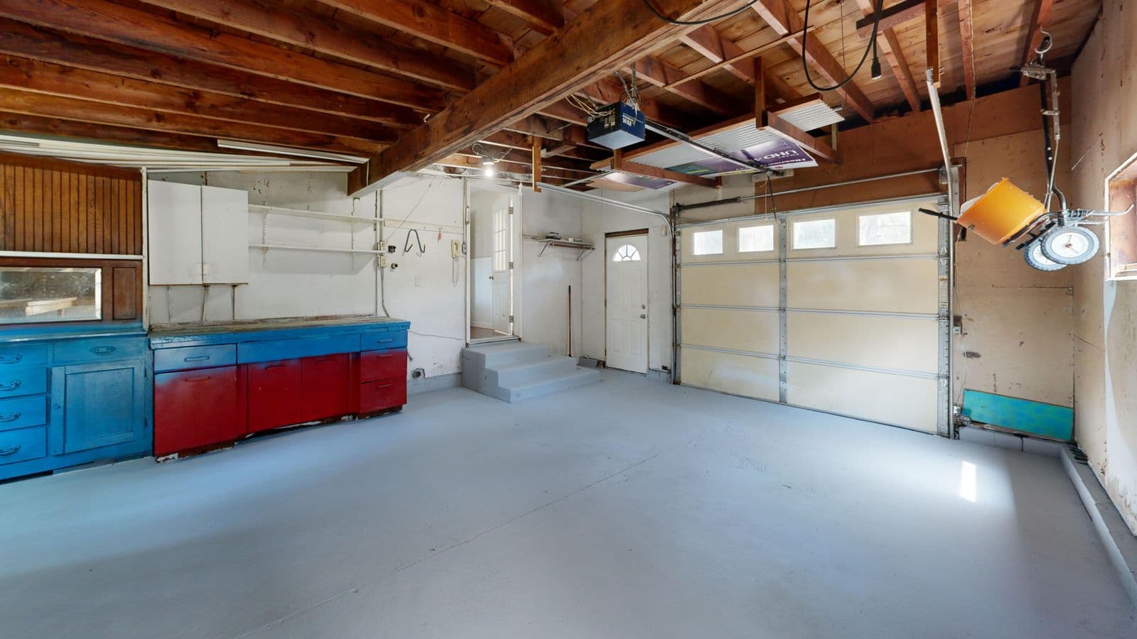 Residential garage interior with a solid-color coated floor and built-in storage cabinets